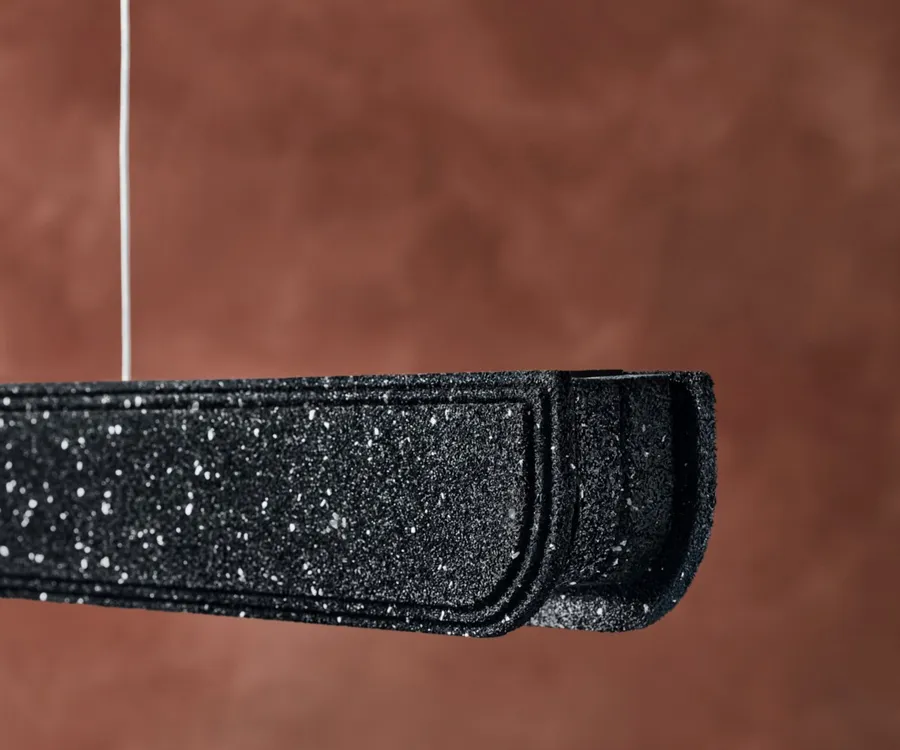 Close view of a moulded black recycled rubber threshold profile with speckled granulate texture