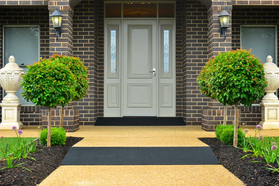 Black recycled rubber threshold and walkway ramps installed at a brick home entry