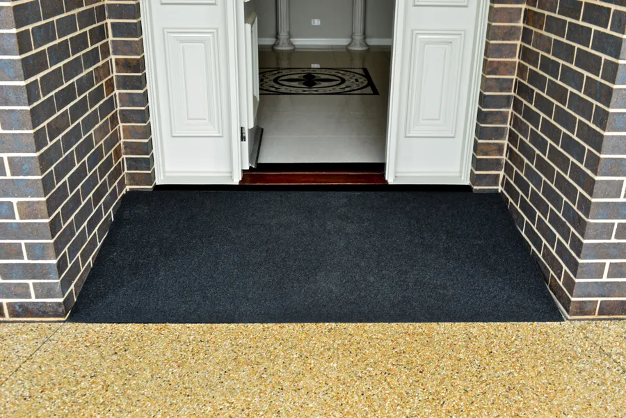 Black recycled rubber threshold ramp fitted between brick piers at double doors