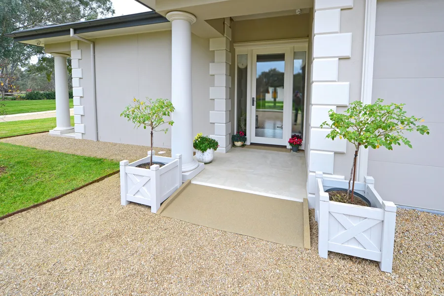 Sand coloured recycled rubber threshold ramp at a rendered home entry